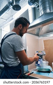 Mechanic Pouring Paint From Container To Bucket On Scales