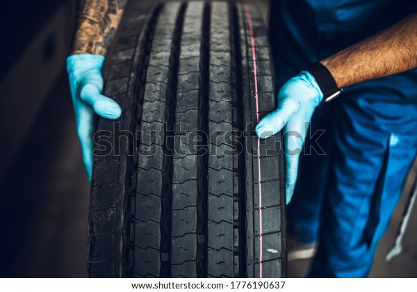 Mechanic pulls bus tire from the warehouse.\
Vehicle repair\
service.