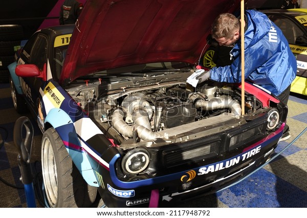 Mechanic of racing team prepares a sports car for\
a race on the track. Checking the technical condition of the car,\
inflating tires, refueling. Drift Cup EEDC 2021 Minsk, Belarus,\
September 26, 2021\
