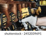 Mechanic reaching for electric screwdriver or electric drill or impact tool on Cordless Tool Shelf Holds  to repair motorcycle in garage. maintenance and repair concept . selective focus