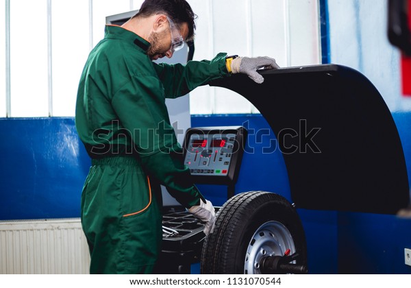 Mechanic removes\
car tire and balancing\
wheels