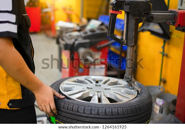 Mechanic removes car tire\
closeup