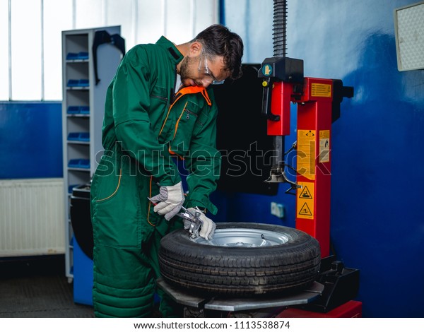 Mechanic removes car tire  Machine for removing\
rubber from