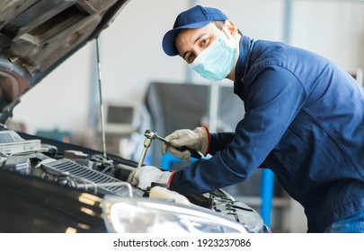 Mechanic repairing a car, covid coronavirus concept