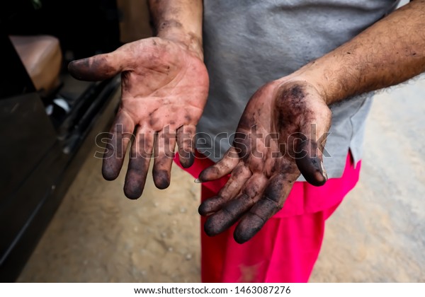 Mechanic, repairing car\
with dirty hands.