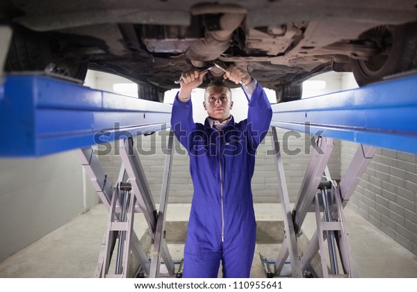 Mechanic repairing\
a car with tools in a\
garage