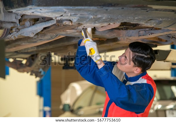 Mechanic repairing a car,Repair of\
machines,Repair specialist,Technical maintenance,Concept of a car\
mechanic inspection.