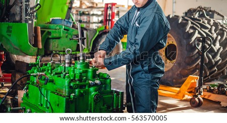Mechanic repairing disassembled engine