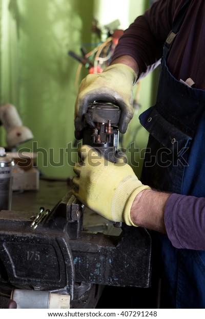 Mechanic repairing electric generator, repair of\
starter \
