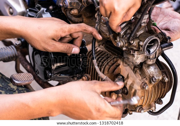 The mechanic is repairing the engine and cleaning\
the spare parts.