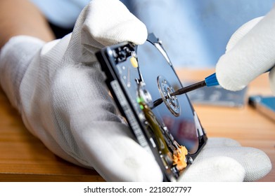 mechanic repairing hard drive, hard drive It is a device for storing data. - Shutterstock ID 2218027797
