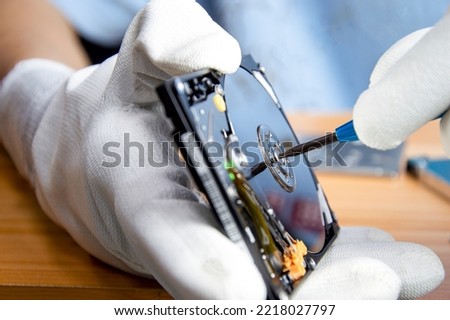 mechanic repairing hard drive, hard drive It is a device for storing data.
