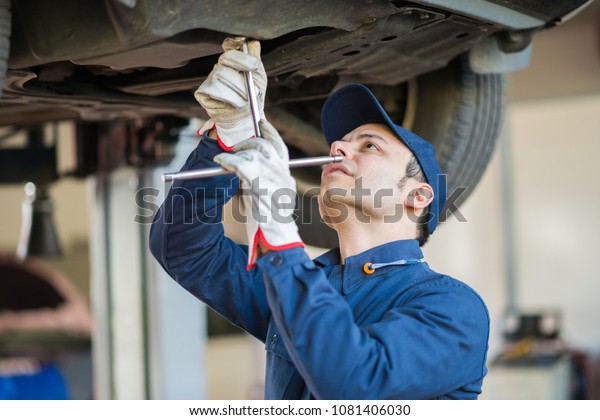 Mechanic repairing a lifted\
car