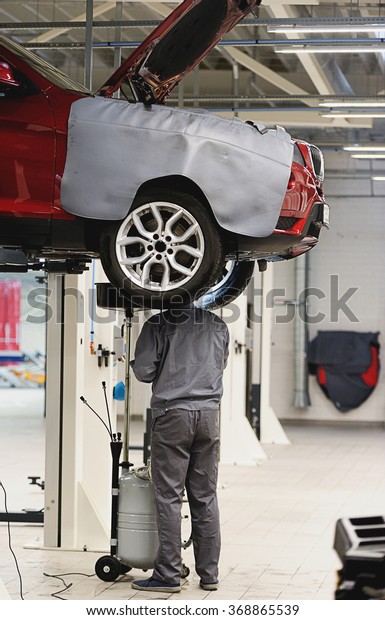 mechanic repairing suspension in car in big and
clean garage