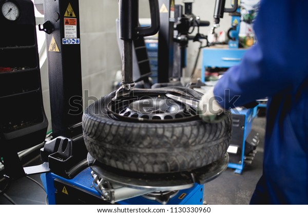 Mechanic\
repairing tire. Worker vulcanize used\
tire.