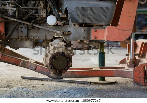 A\
mechanic is repairing a tractor used in\
agriculture.