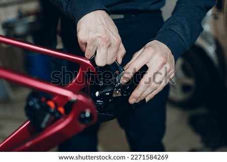 Mechanic repairman assembling with wrench custom bicycle in workshop