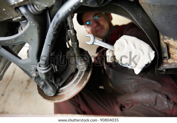 mechanic repairman at car break disk maintenance\
work by using spanner
