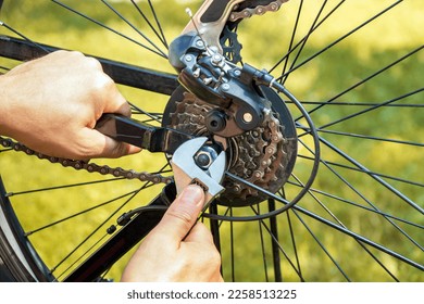 A mechanic repairs a bike on the street with a wrench. Close-up of the master hands during urgent repairs. - Powered by Shutterstock