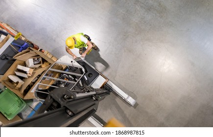 Mechanic repairs forklift in warehouse, view from above