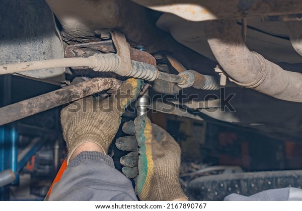 Mechanic repairs the
running gear of a car car. Hands of a mechanic close-up. Small
business concept.