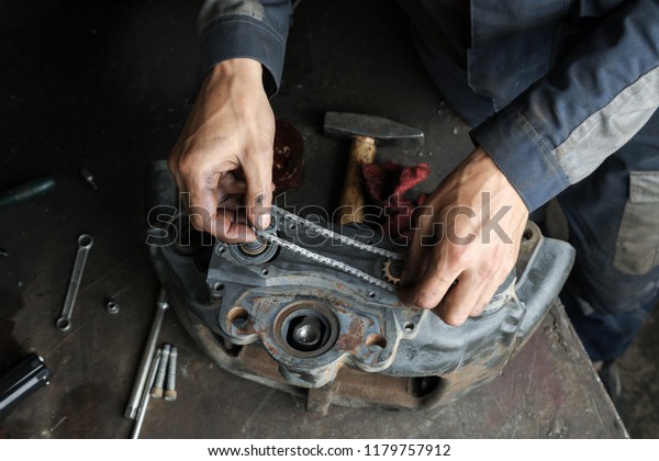The mechanic repairs the truck.\
Repair and adjustment of brake caliper. Chain support\
mechanism.
