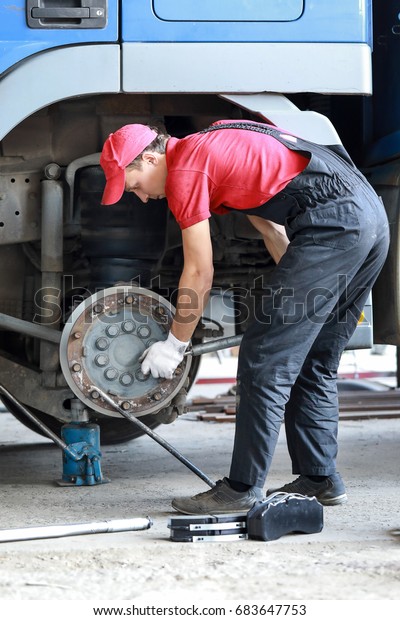 A
mechanic repairs a truck. Replace brake disc and
pads