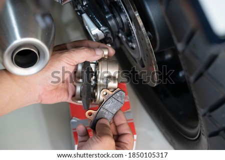 mechanic Replace and adjust motorcycle Rear Brake system,maintenance,repair motorcycle concept in garage .selective focus 