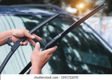 Mechanic replace windshield wipers on car. Replacing wiper bladesChange cars wiper blades. Technician Man changing windshield wipers blades on car.