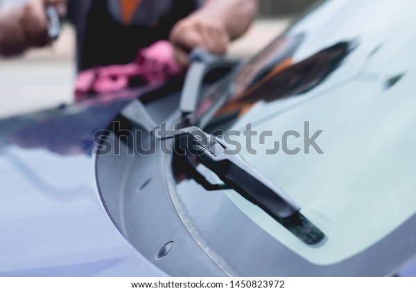 Mechanic replace windshield wipers on car.
Replacing wiper blades
Change cars wiper blades. Technician Man
changing windshield wipers blades on
car.