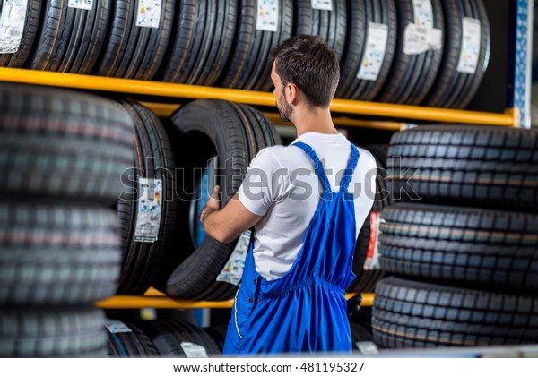 Mechanic sale a\
new tire for car at a tire store\
