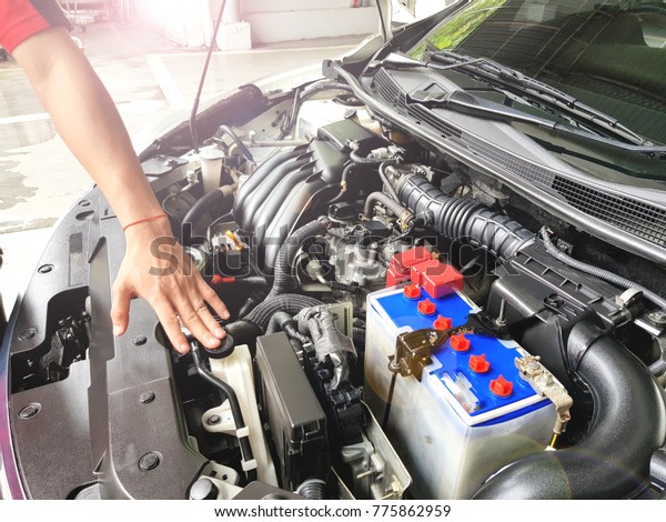 Mechanic with scan\
tool diagnosing car in open hood. Checking car engine before\
driving to travel, Soft\
focus