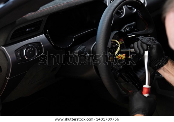Mechanic screwing\
the steering wheel and air\
bag