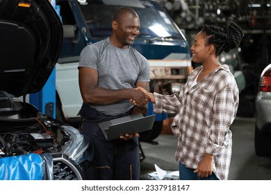 mechanic shaking hands with customer after fix a car in automobile repair shop - Powered by Shutterstock