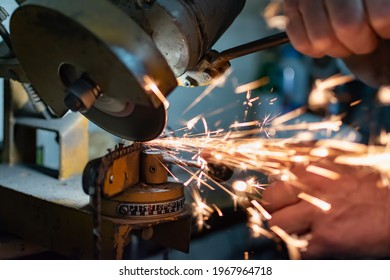 Mechanic sharpening a chainsaw chain with a keystone - Powered by Shutterstock