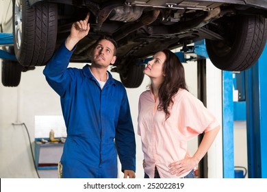 Mechanic Showing Customer The Problem With Car At The Repair Garage