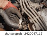 The mechanic is showing the lambda sensor connector in his hand. Auto service. Car repairing.