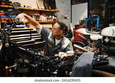 Mechanic squeezing and holding clutch lever down to check if engine of motorcycle works