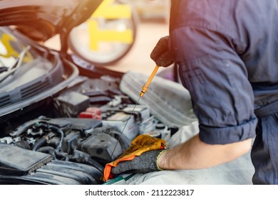 mechanic staff looking dipstick car engine oil check and change in garage