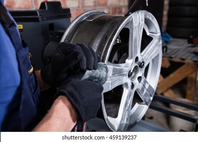 Mechanic Straightening Car Wheel Rim.