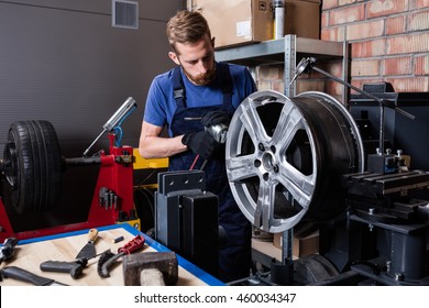 Mechanic Straightening Car Wheel Rim.