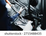 Mechanic with tablet computer control and fix problem of hydraulic hoses from industrial mining truck.