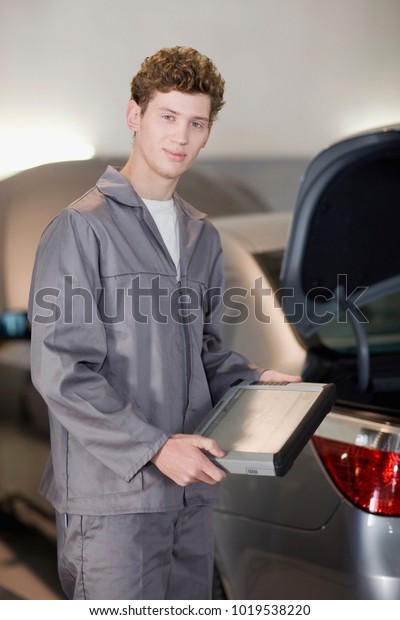Mechanic with tablet\
computer in garage