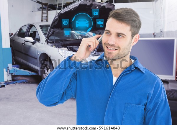 Mechanic talking on mobile phone with car mechanic\
interface in garage