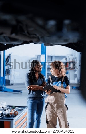 Mechanic talks with client about car during bicycle maintenance.