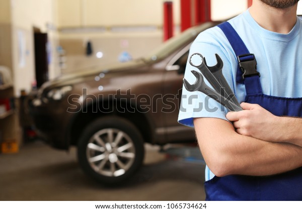 Mechanic with tools in garage. Tire and other\
car services