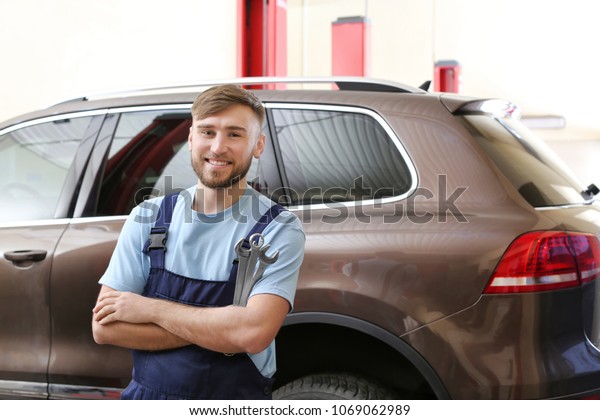 Mechanic with tools in garage. Tire and other
car services