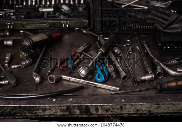 Mechanic tools on dirty metal desk. Car wrenches,\
screwdrivers. Garage tools.\
