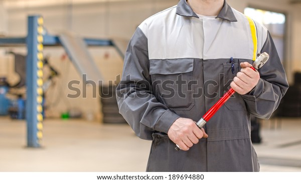 Mechanic with\
torque wrench at auto repair\
shop.