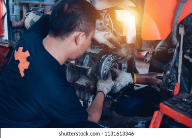 Mechanic Tractor Working Under The Car And Clutch At Car Repair Shop Tractor